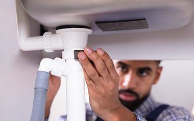 Man working on his undersink plumbing