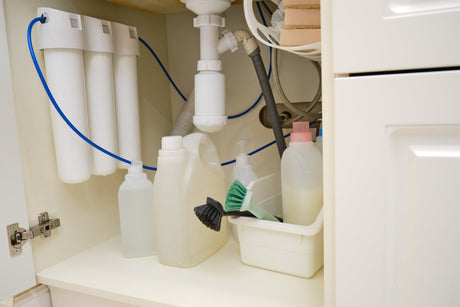 Under-sink water filter system installed below a kitchen sink